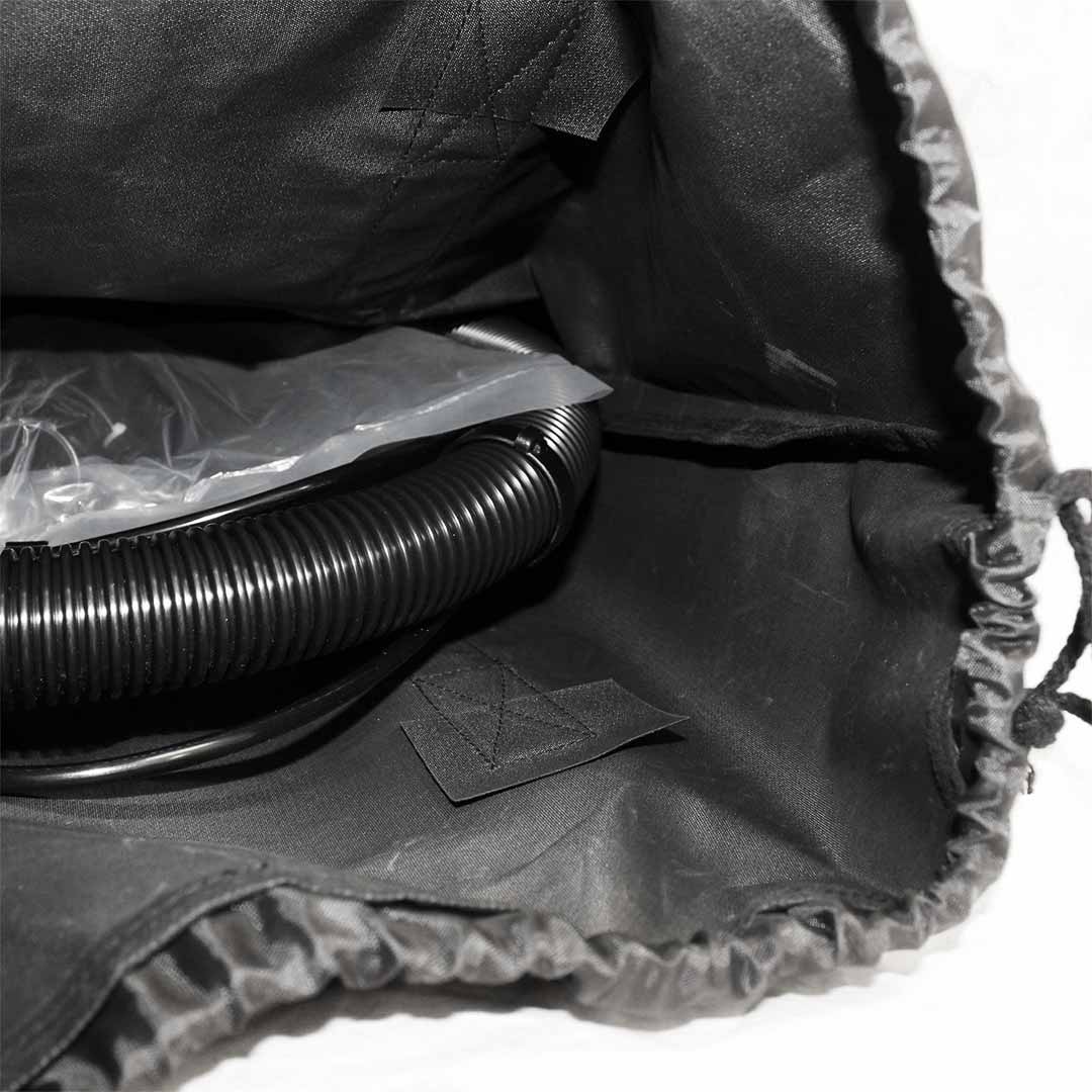 Interior view of a black carry bag partially open, showing a coiled hose and plastic packaging inside.