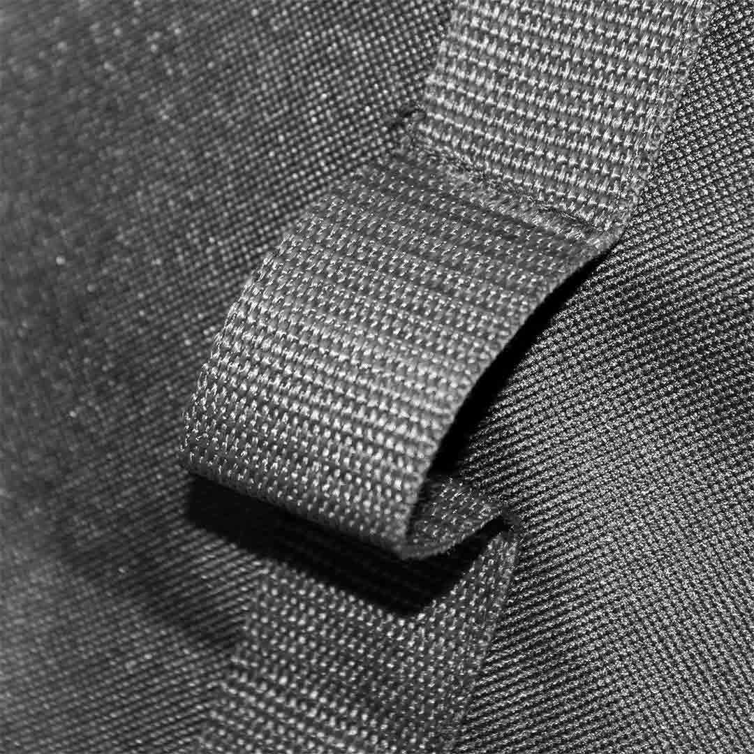 Close-up of the black bag's fabric and strap texture, showcasing the extension pipe slots.