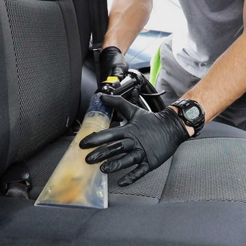 Close-up view of auto detailing with the Aqua Pro Vac Extractor cleaning a car seat, showing the dirt extraction process.